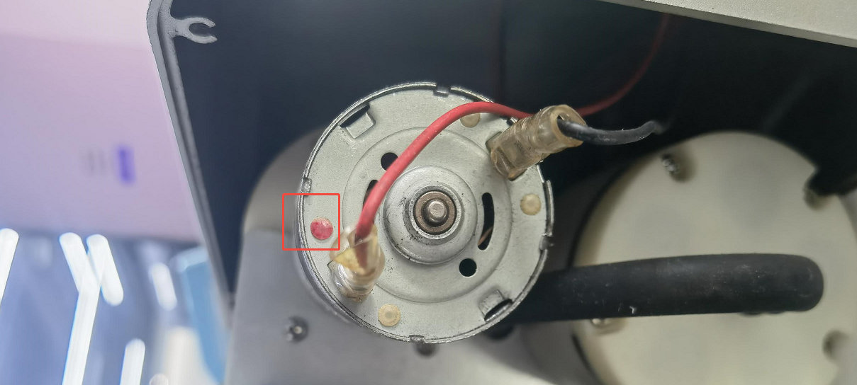 Punto rojo que marca el polo positivo del conector de la bomba
